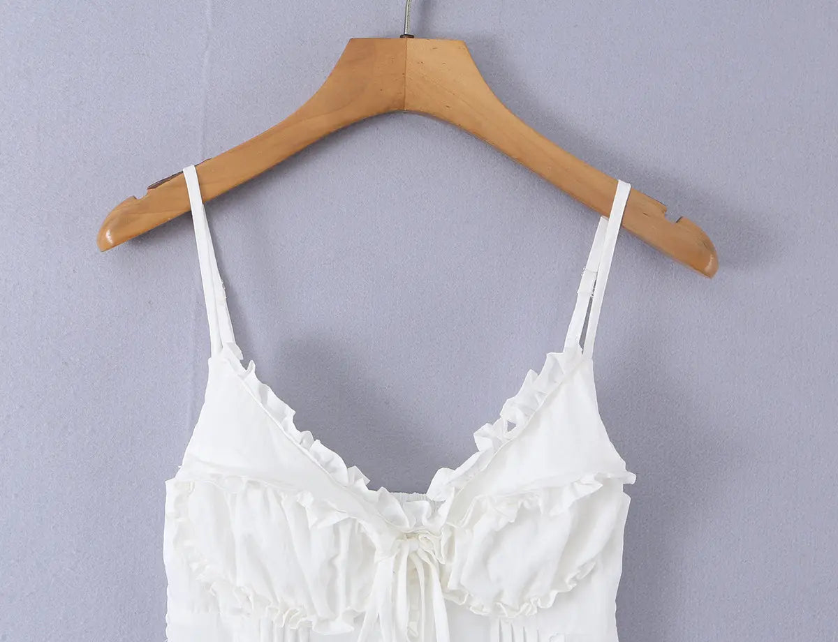 White ruffled cami top hanging on wooden hanger, full front view