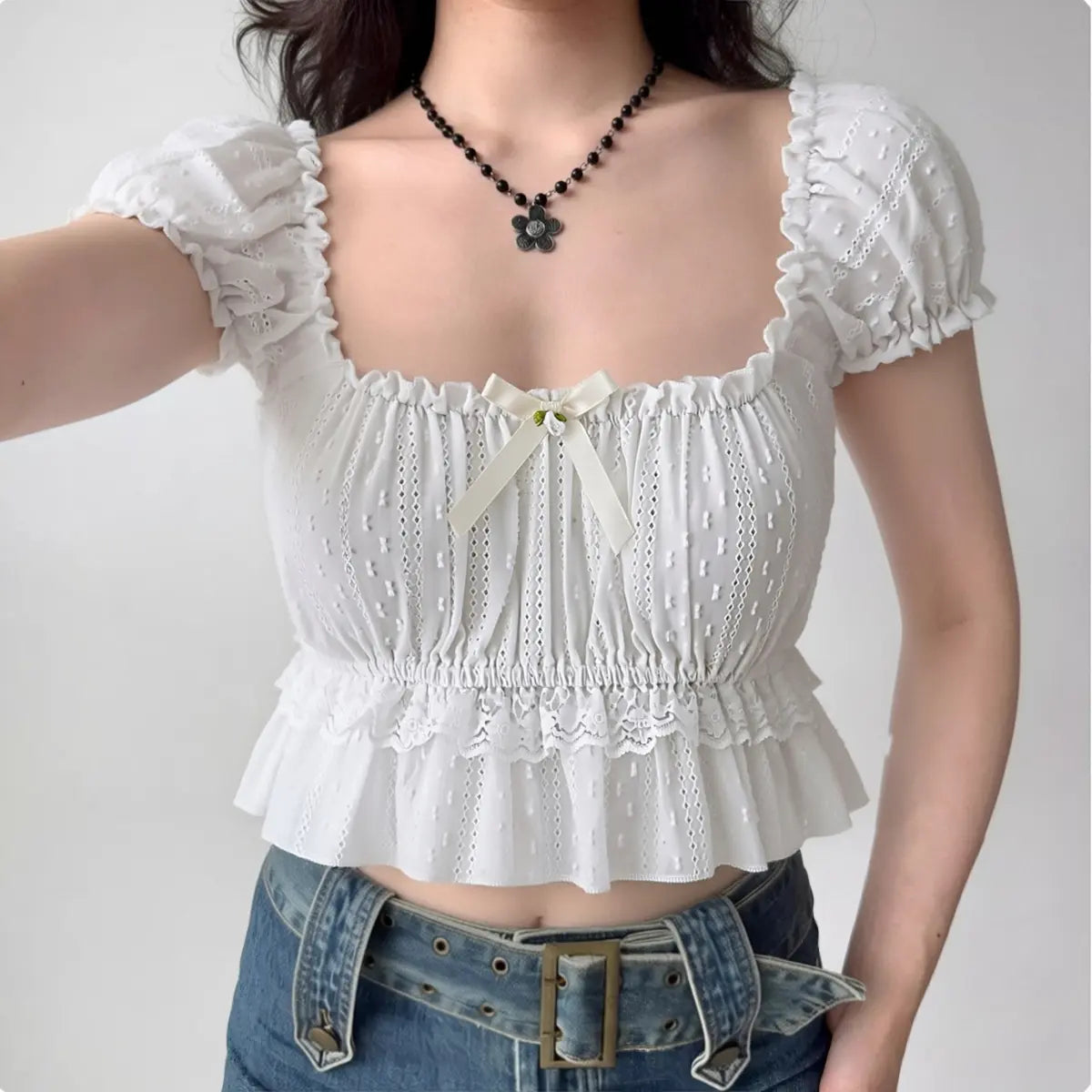 Model wearing white square-neck puff-sleeve cropped top with bow detail, cottagecore-inspired ruffle blouse
