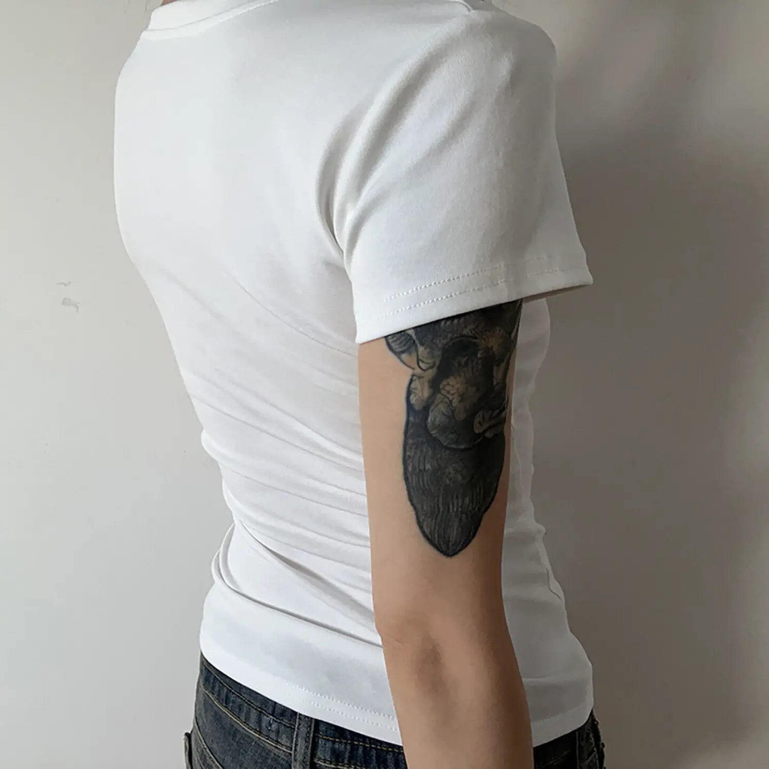 Back detail view of white U-neck ribbed slim short sleeve t-shirt, showing back silhouette and sleeve stitching