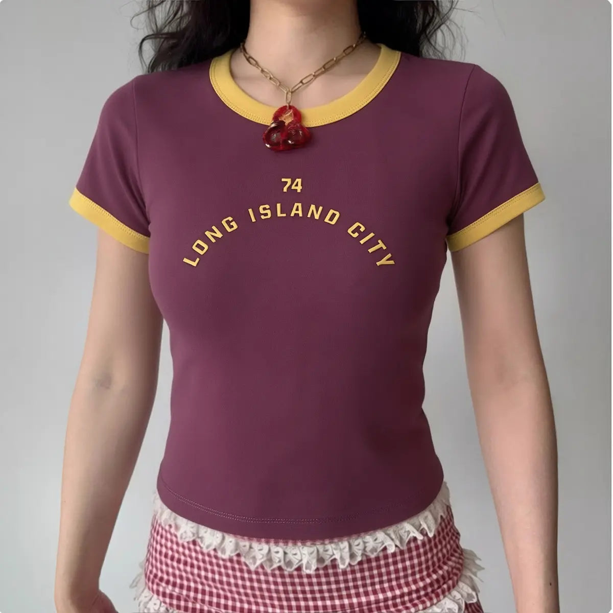 Model wearing wine red "Long Island City" cropped ringer tee with yellow trim, retro Y2K-inspired top