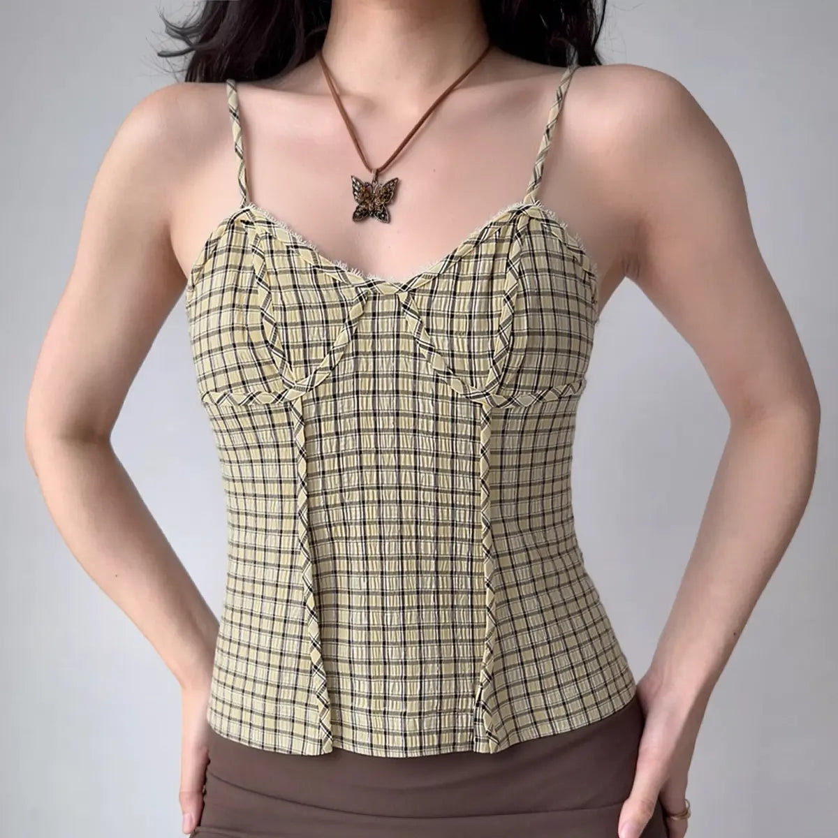 Model wearing yellow black gingham cami top with textured fabric and corset-style seams, vintage-inspired bustier