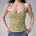 Model wearing yellow green floral halter-neck corset top with sweetheart neckline, form-fitting bustier tank