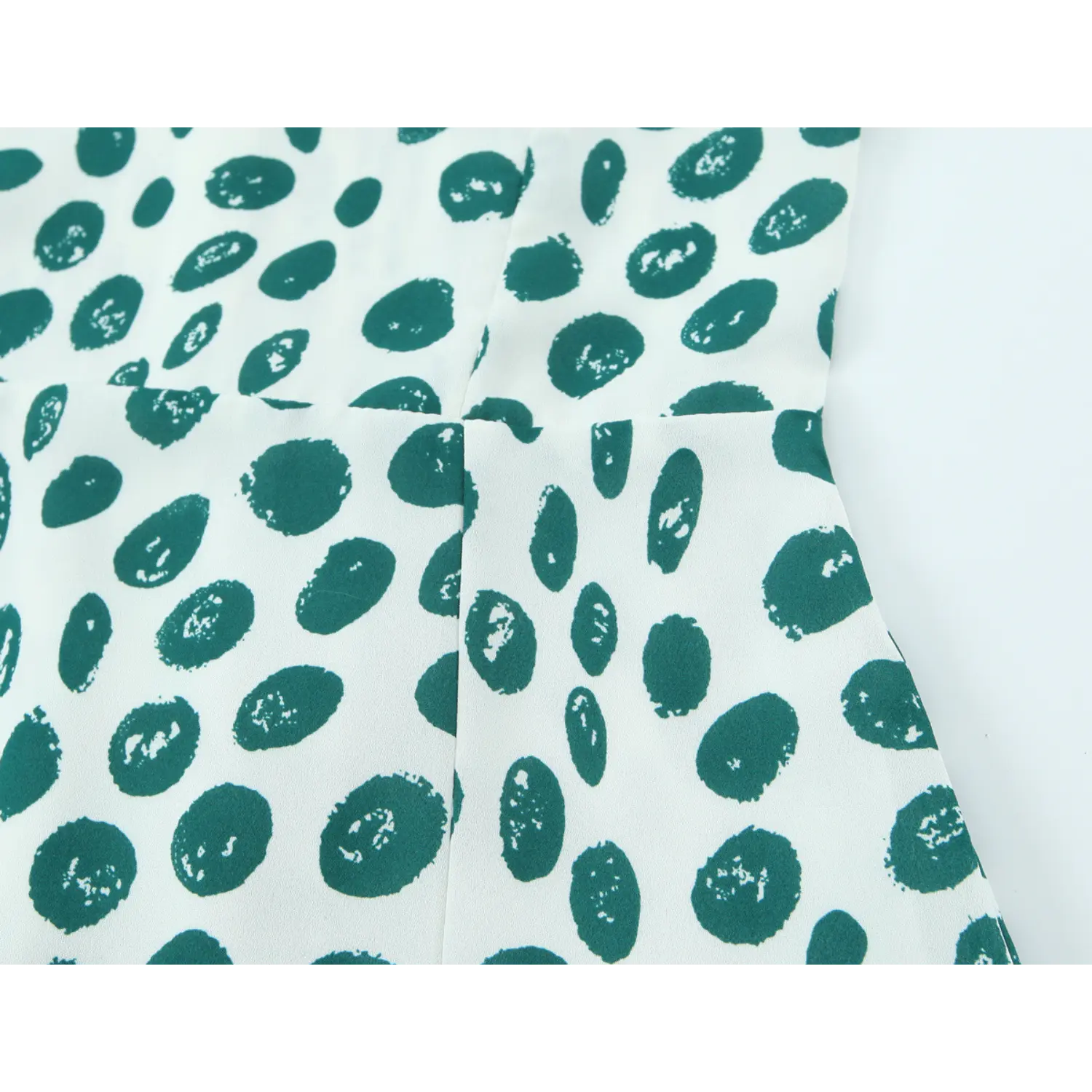 Bodice partial close-up structured bust dart stitching, wide matching print shoulder straps, irregular brushstroke green polka dot lightweight woven fabric