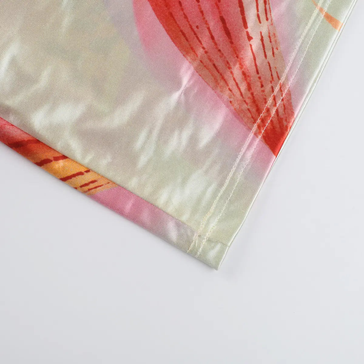 Hem detail of the satin dress, showing the finished edge and smooth fabric texture