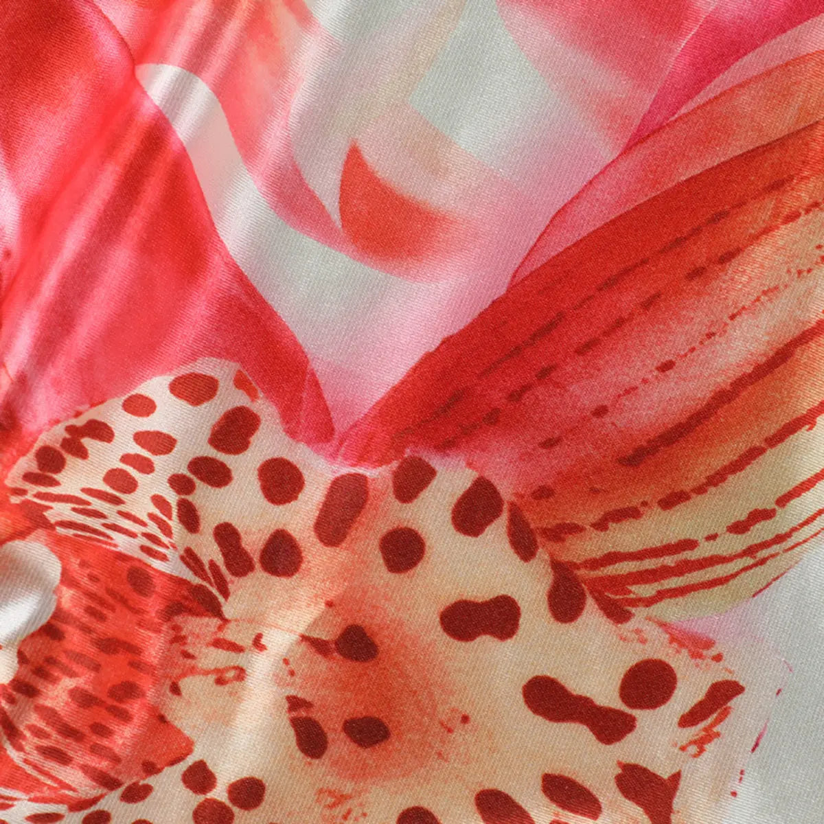 Close-up of the leopard and watercolor print on the satin dress, highlighting the red and orange patterns