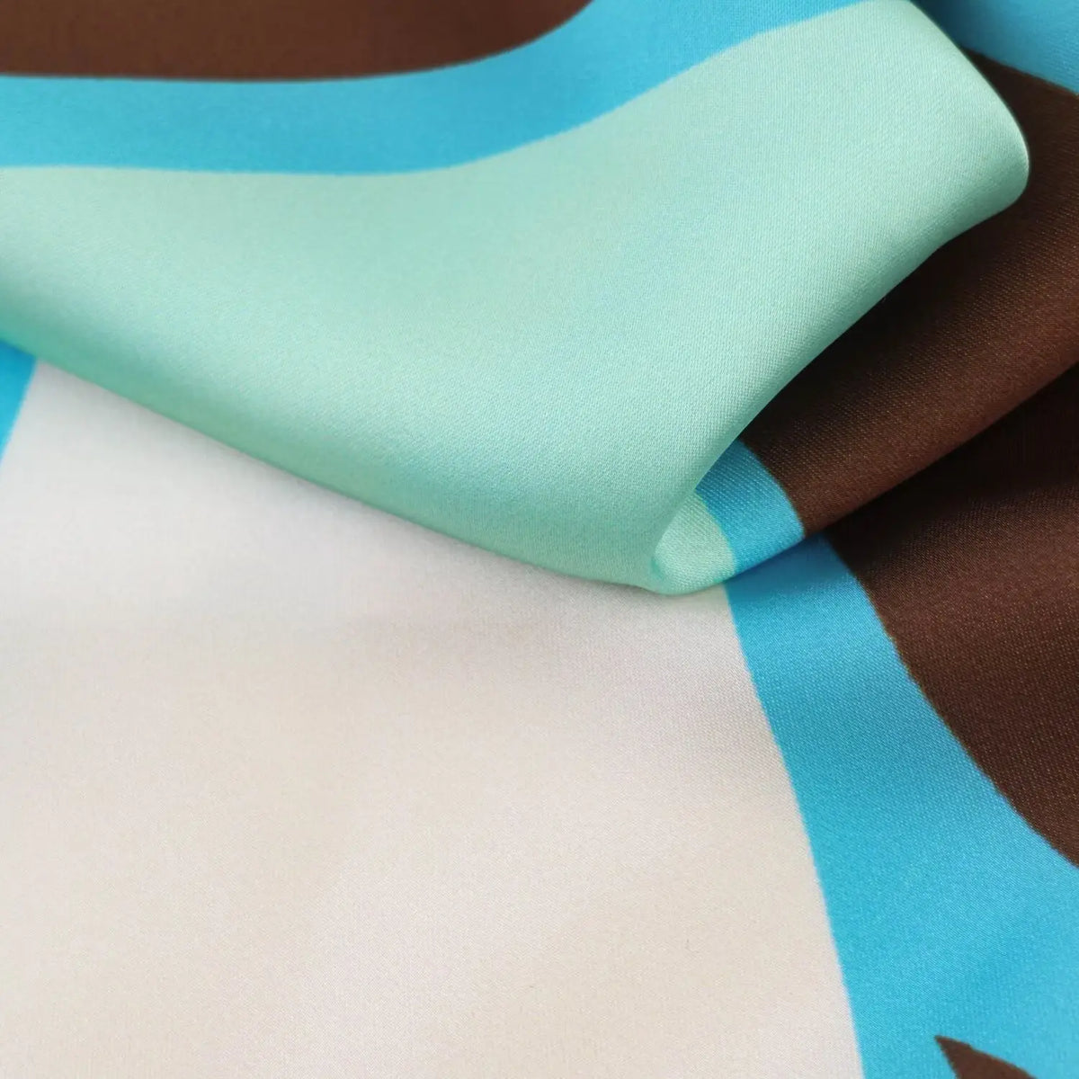 Close‑up of smooth satin fabric texture, multicolor abstract geometric print
