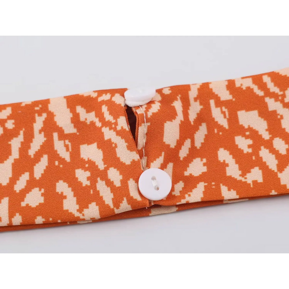 Close-up of sleeve cuff with white buttons for orange abstract speckled print maxi dress