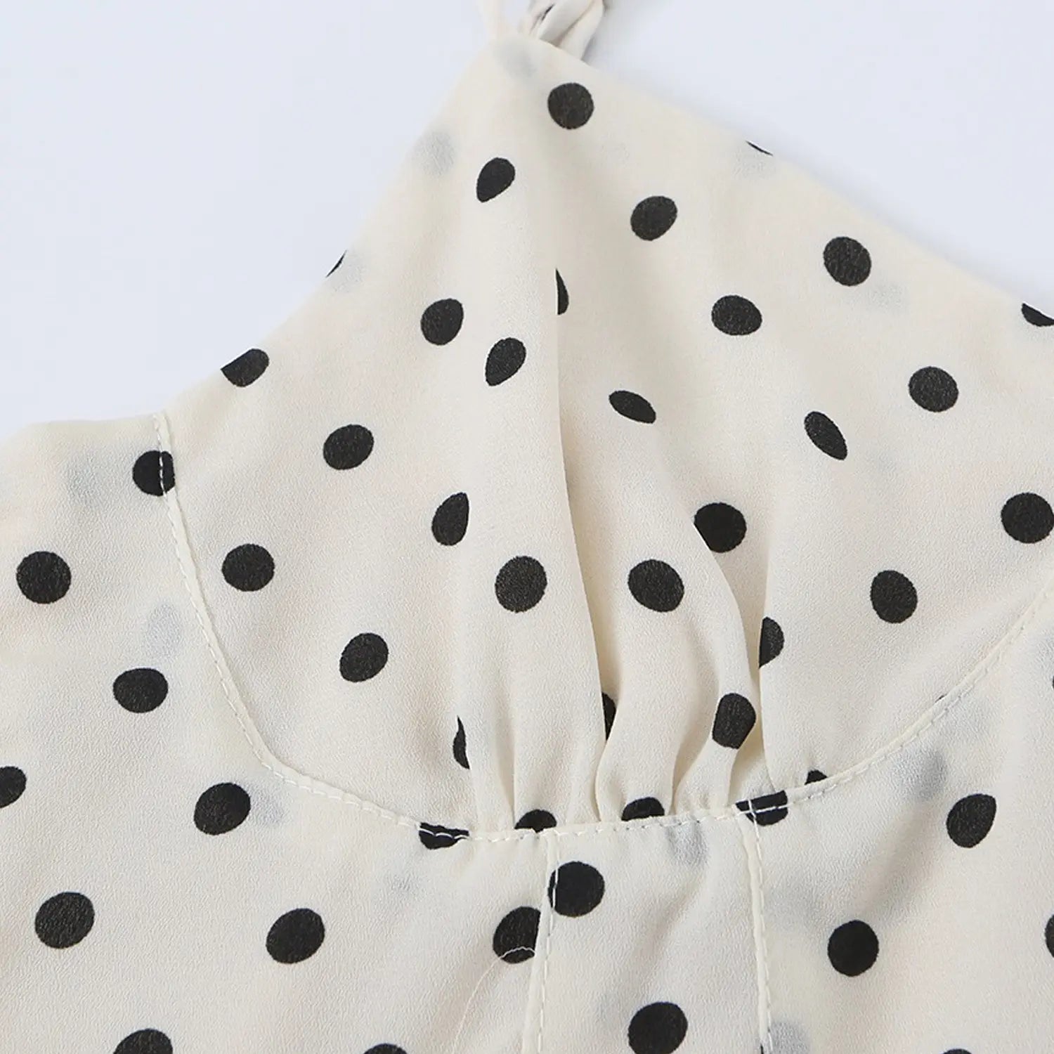 Adjustable polka dot fabric strap cami top shoulder flat close-up, matching dot thin straps metal sliders and gathered neckline stitching
