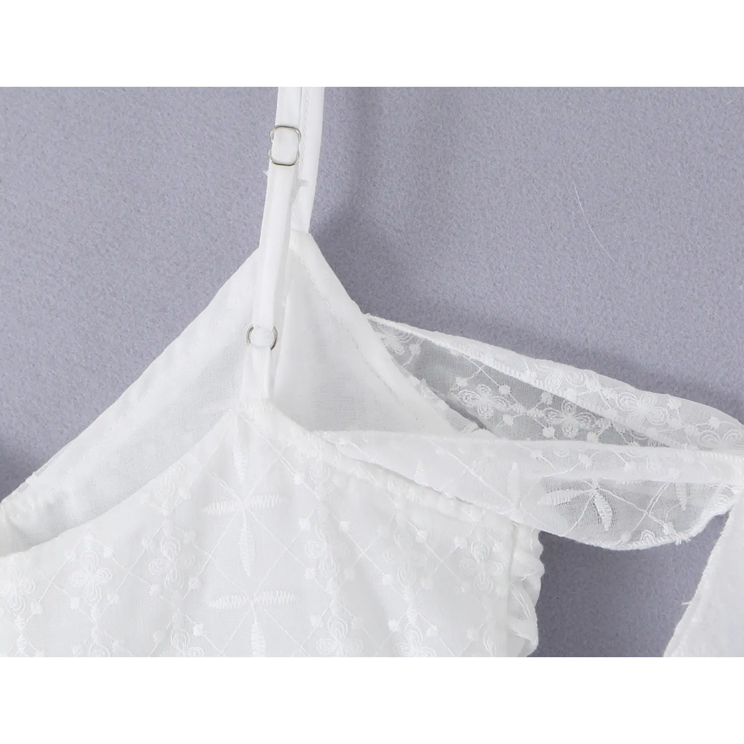 Thin spaghetti strap metal slider buckle macro close-up, double embroidered binding neck sheer off-shoulder panel neat serging stitching detail