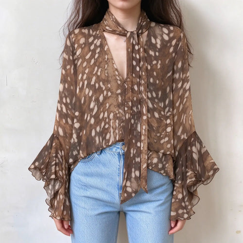 Model wearing animal print tie neck ruffle blouse with jeans, front view