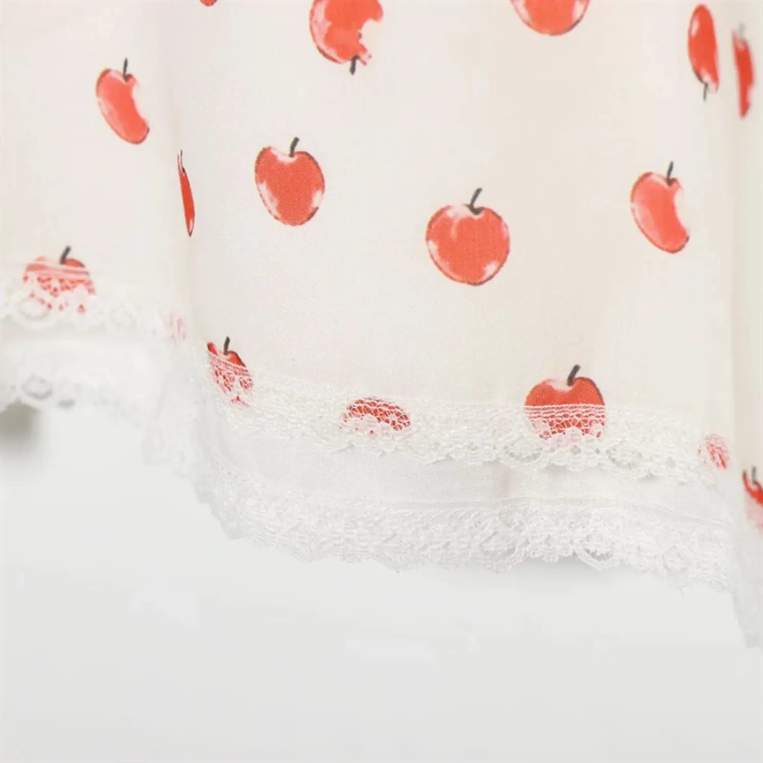 Macro shot skirt bottom scalloped lace trim hem, delicate hollow lace edging, apple print fabric overlay