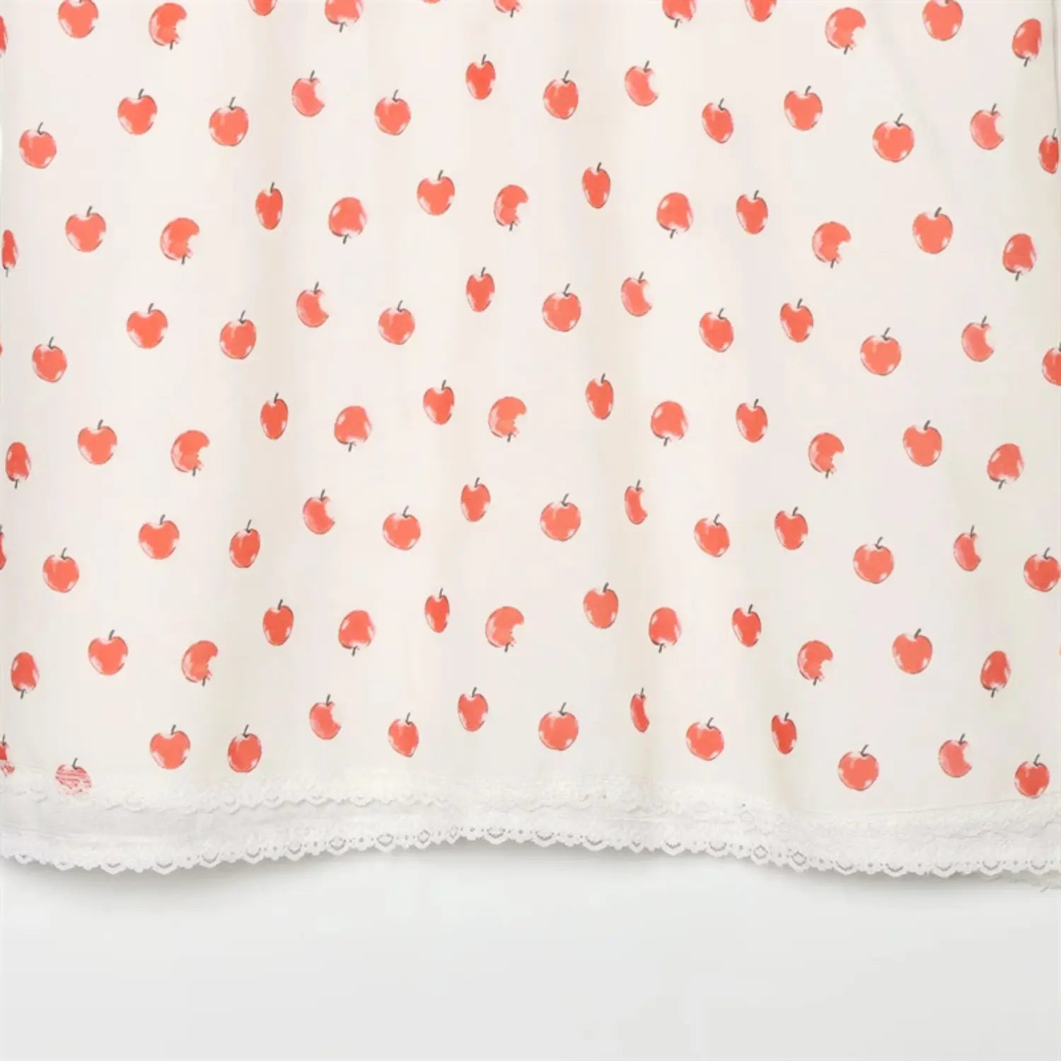 Full skirt fabric overview, evenly distributed all-over red apple print, natural lightweight drape, full lace hem at bottom edge