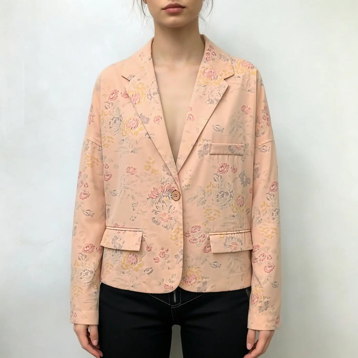 Model wearing apricot floral print cropped blazer with black trousers