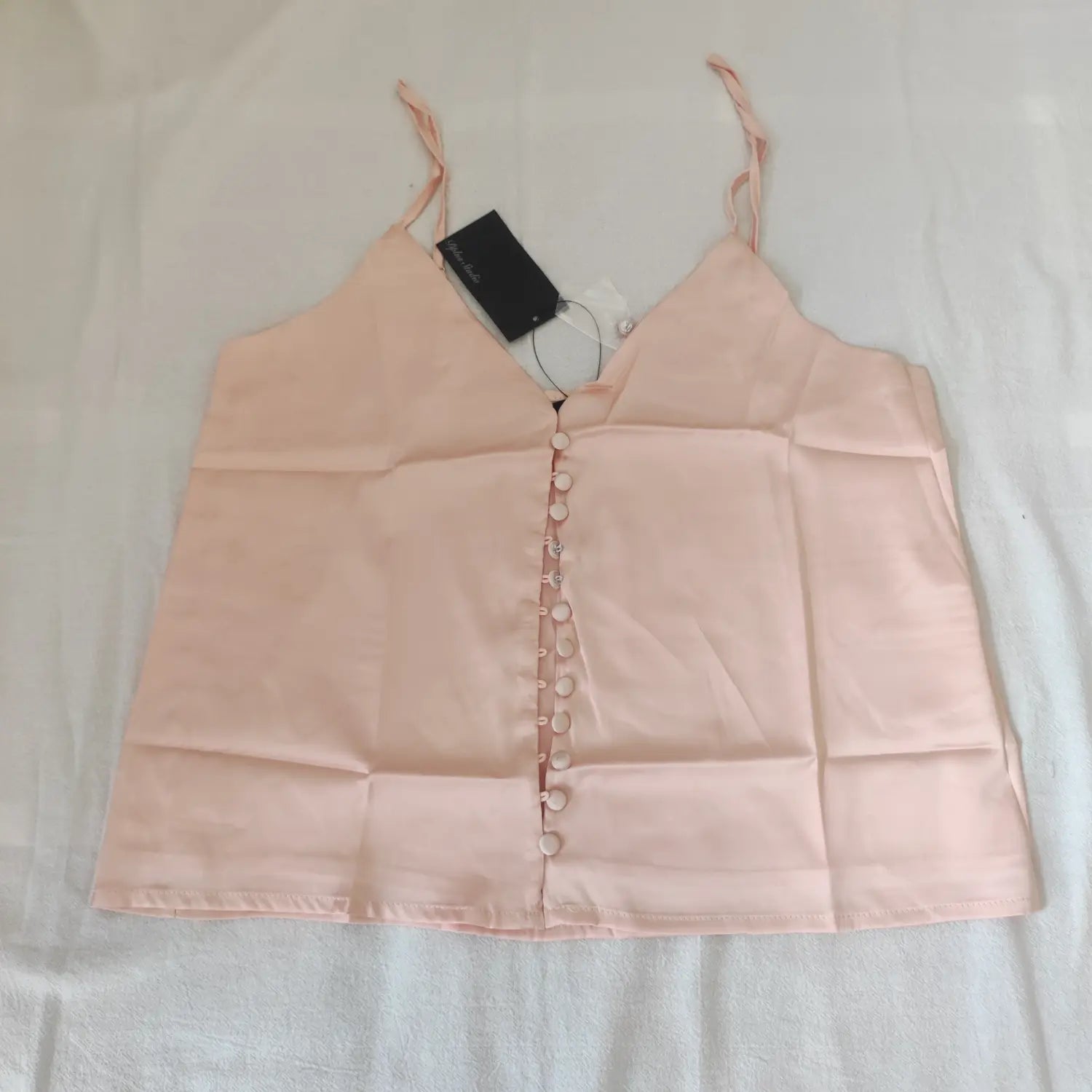Flat lay front view apricot pink satin v‑neck cami top with full front buttons and brand tag