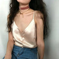 Model torso close‑up apricot pink satin v‑neck cami top spaghetti strap casual outfit