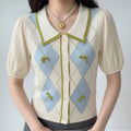 Model wearing preppy college argyle knit mixed sleeve blouse, green trim lapel collar, mini fabric bow diamond print, cream bubble short sleeves, casual daily sweet outfit with pearl necklace
