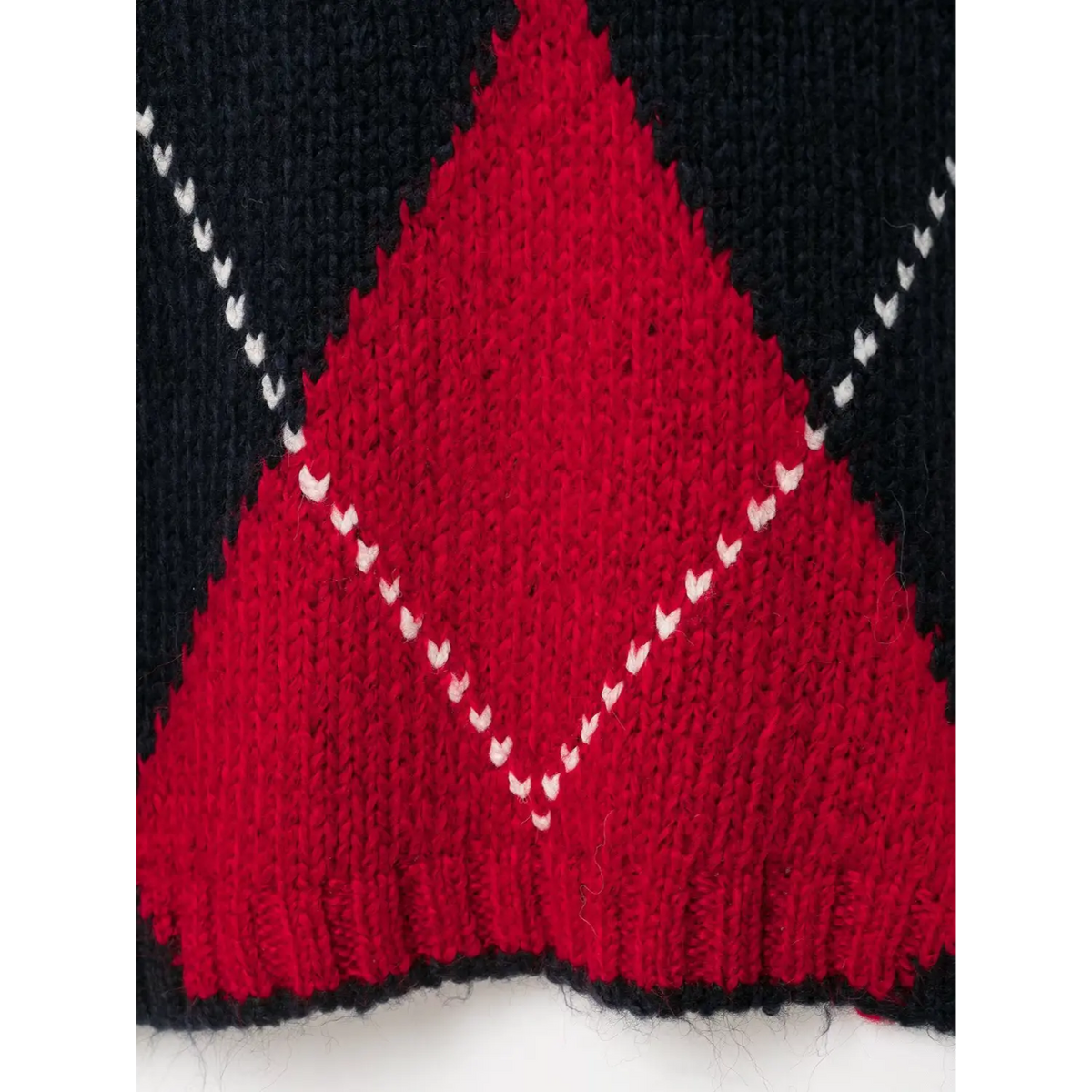Close-up of red diamond with white V-stitch