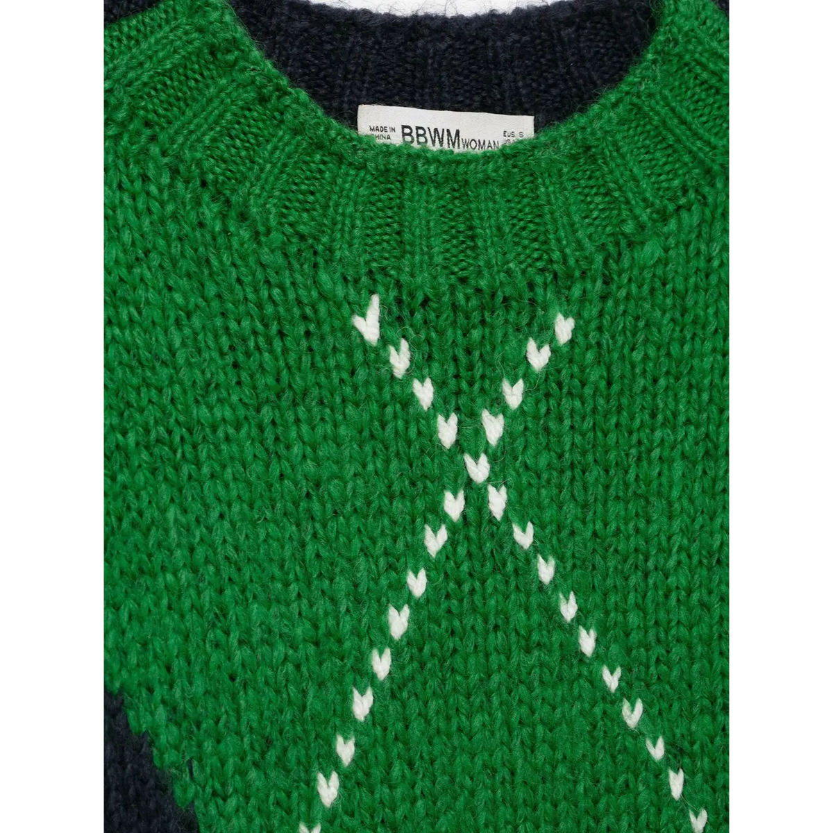 Close-up of white V-stitch on green diamond