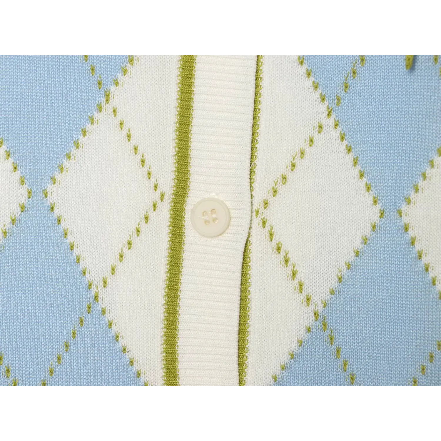 Close-up front button placket of argyle knit top, off-white round resin button, green contrast rib piping, blue white diamond jacquard stitch detail