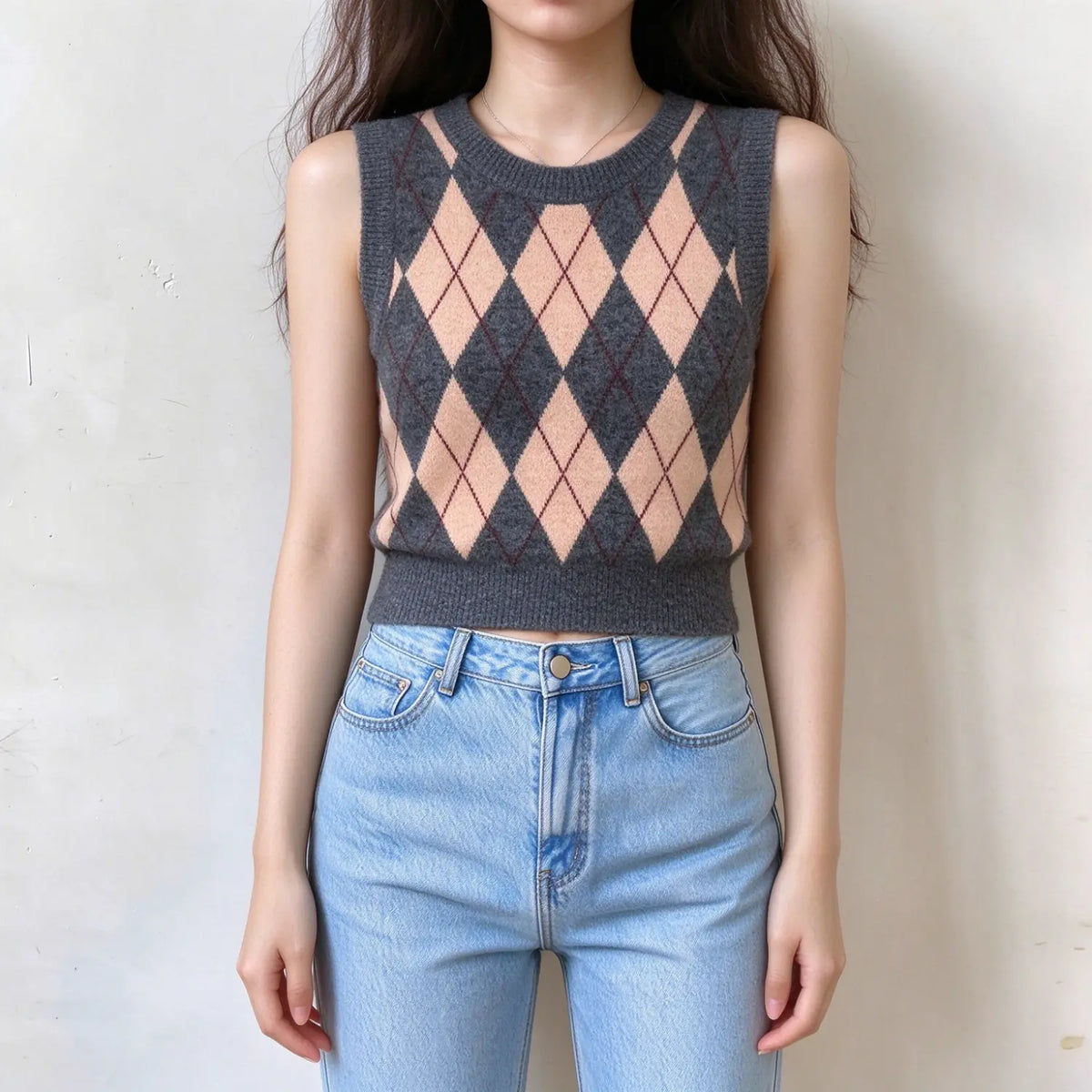 Model wearing grey and peach argyle knit vest, round crew neck, sleeveless cropped sweater vest, classic diamond pattern, soft knit fabric