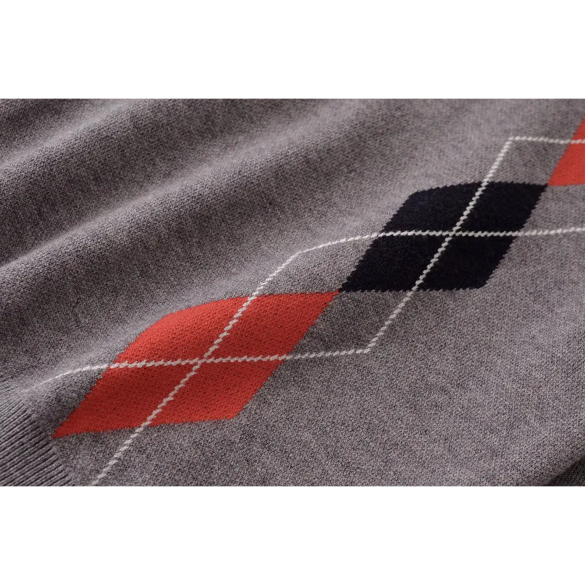 Close-up of red and black argyle diamond knit texture with white outline