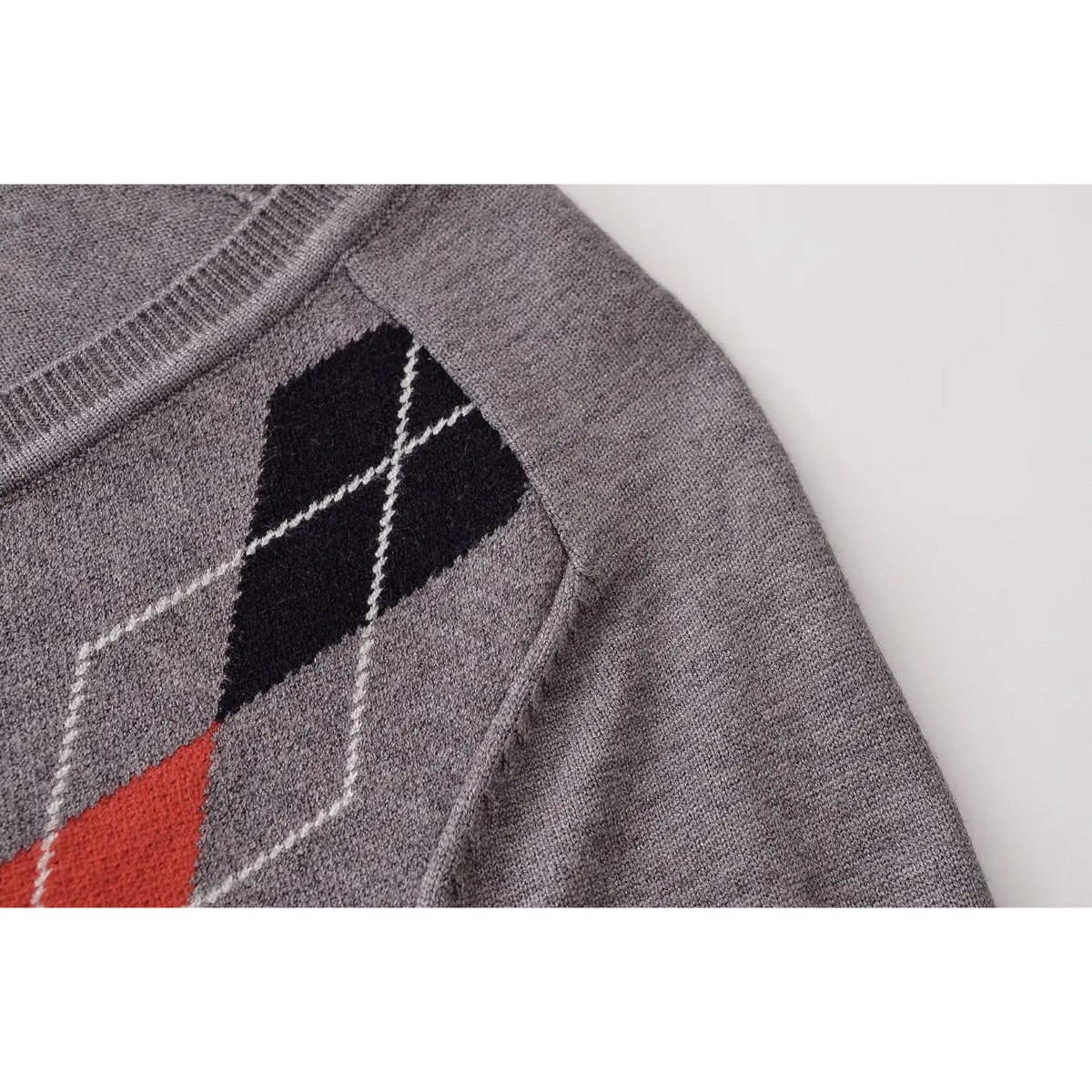 Close-up of black argyle diamond at shoulder and raglan seam