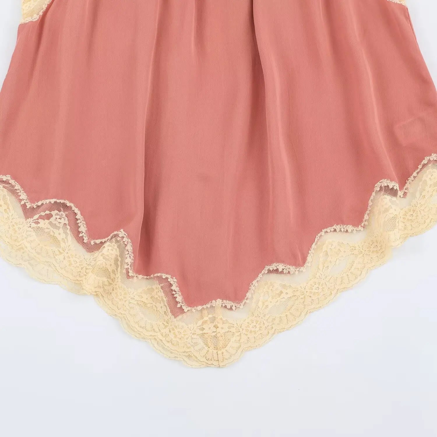 Closeup flat shot of irregular asymmetrical hem with vintage cream scalloped lace border