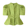Full front flat lay of avocado green polka dot blouse, split stand collar, puff short sleeves, two matching fabric covered buttons, waist shaping darts, flared peplum hem, glossy satin fabric