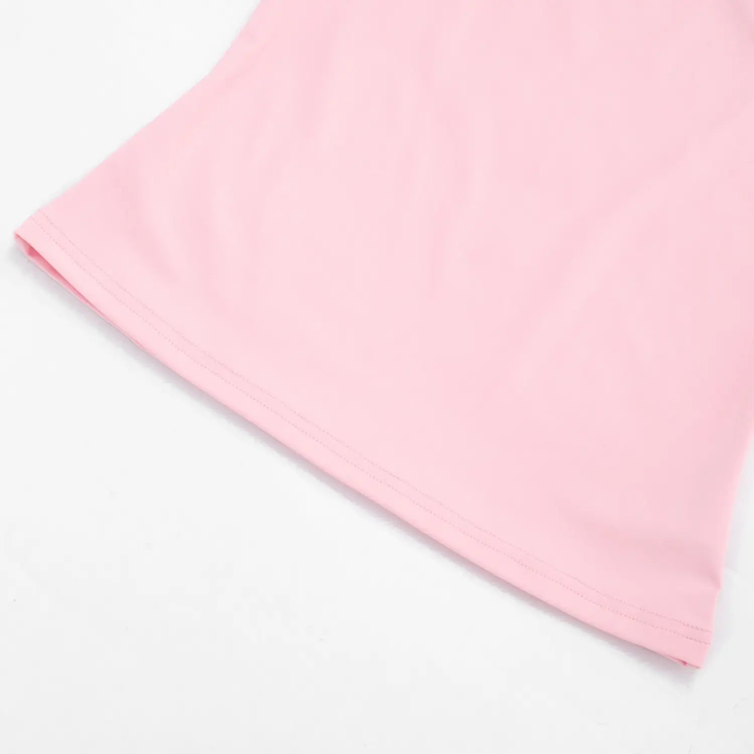 Close-up texture shot of cropped halter tank top hem, soft light pink stretch fabric with neat double parallel straight stitching, clean folded hem edge for durability, matte smooth knit material