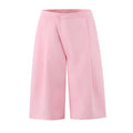 Full front flat lay of baby pink high waist midi pants, wrap front overlapping panel, wide leg silhouette, clean waistband, smooth woven suiting fabric