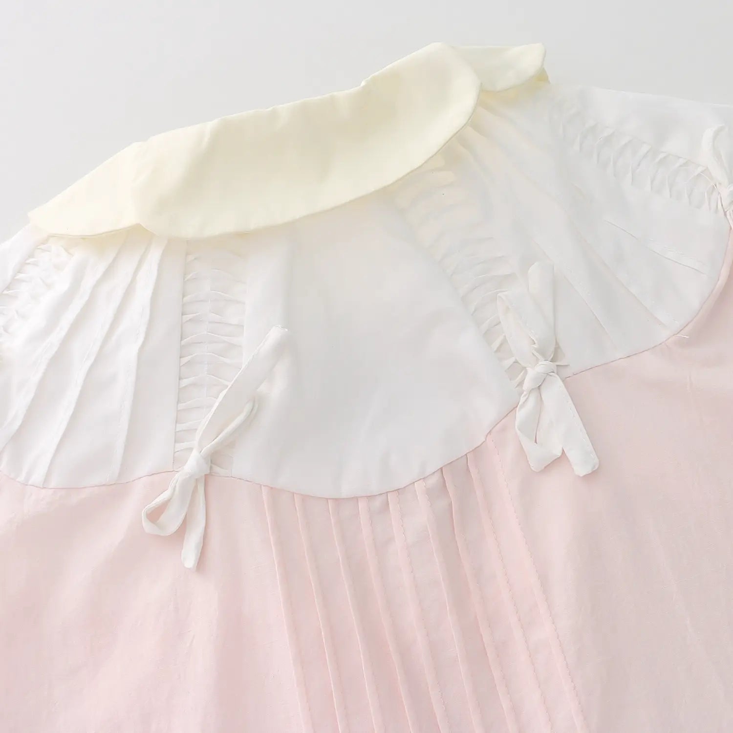Back double cream contrast ruffle collar full macro shot, four symmetrical white shoulder bows collar elastic shirring smooth spliced stitching whole neck design craft shot