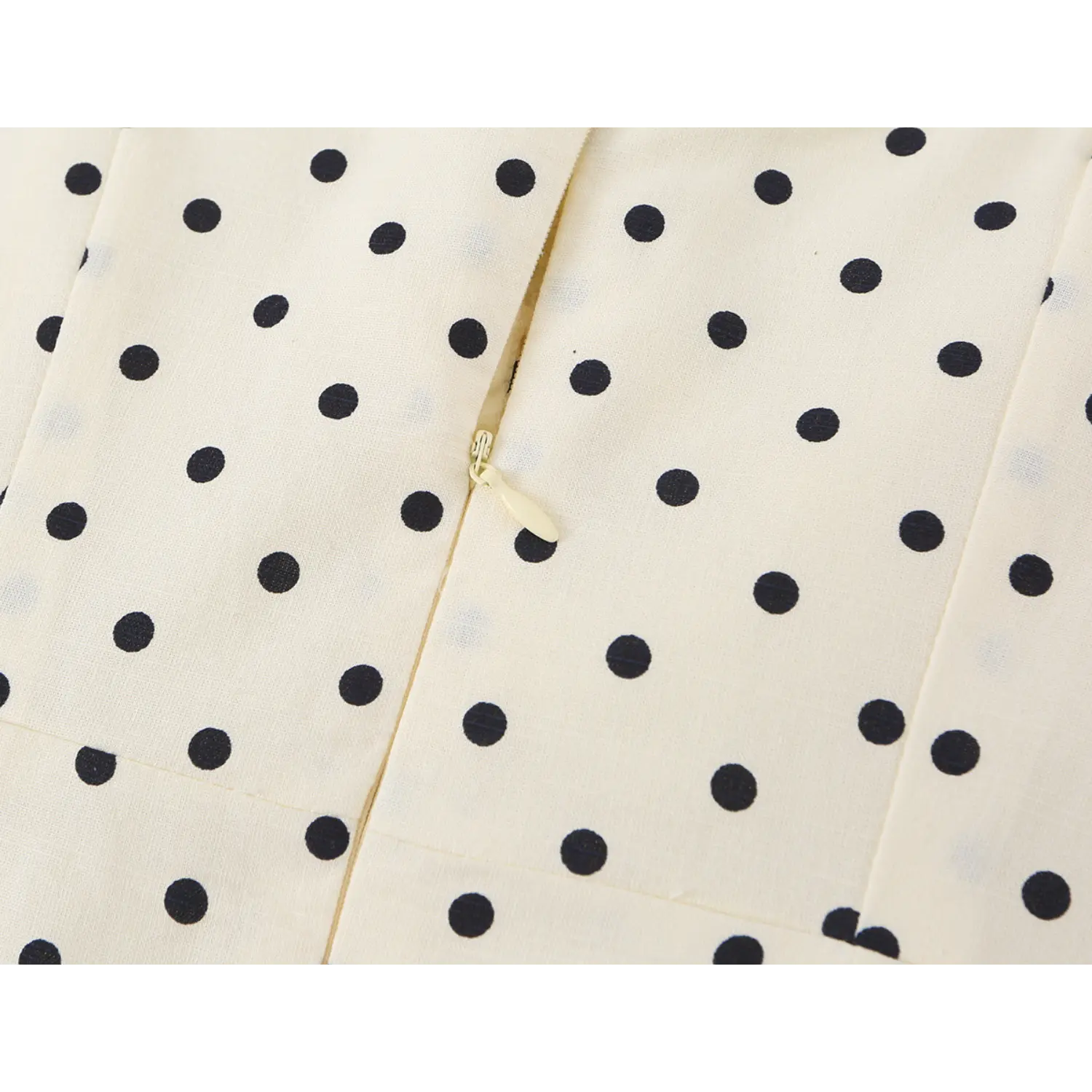 Center back invisible zipper macro close-up, matching cream fabric tape, smooth metal pull tab
