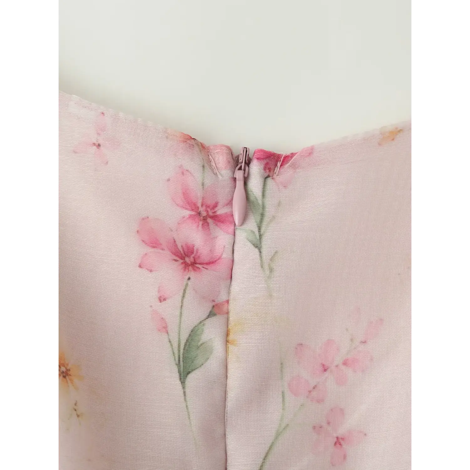 Back center invisible pink zipper macro close-up, matching floral chiffon fabric cover tape