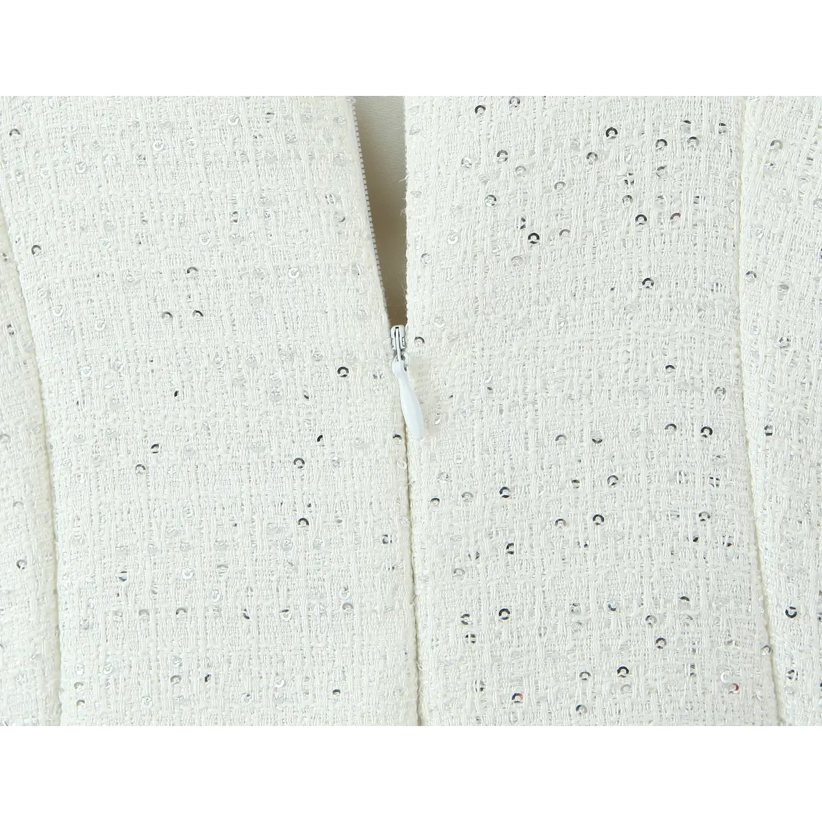 Center back invisible zipper close-up, matching cream tape zipper on sequin tweed woven fabric.