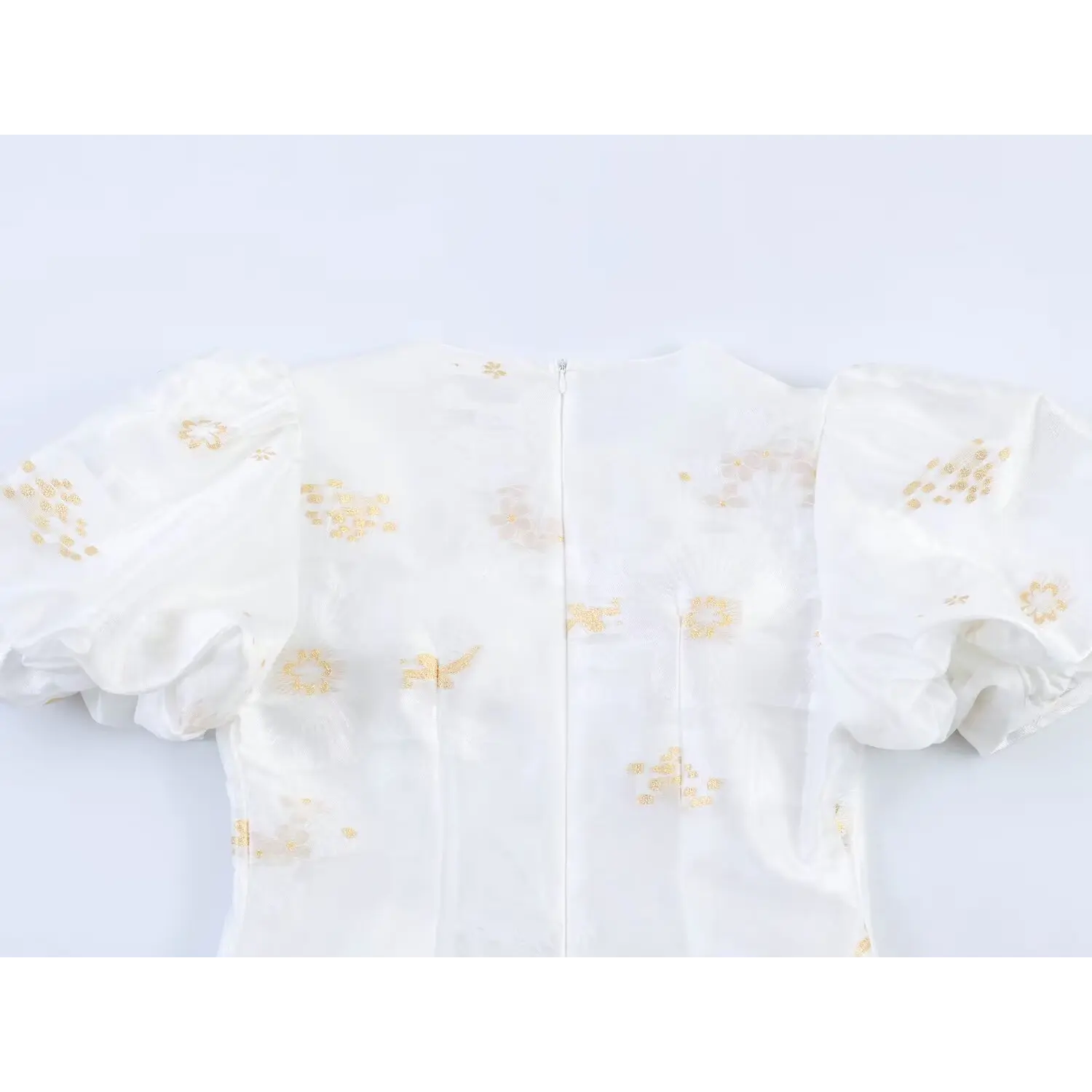 Dress upper back full partial shot, oversized sheer organza puff sleeves, vertical center invisible zipper, all-over golden bird floral print