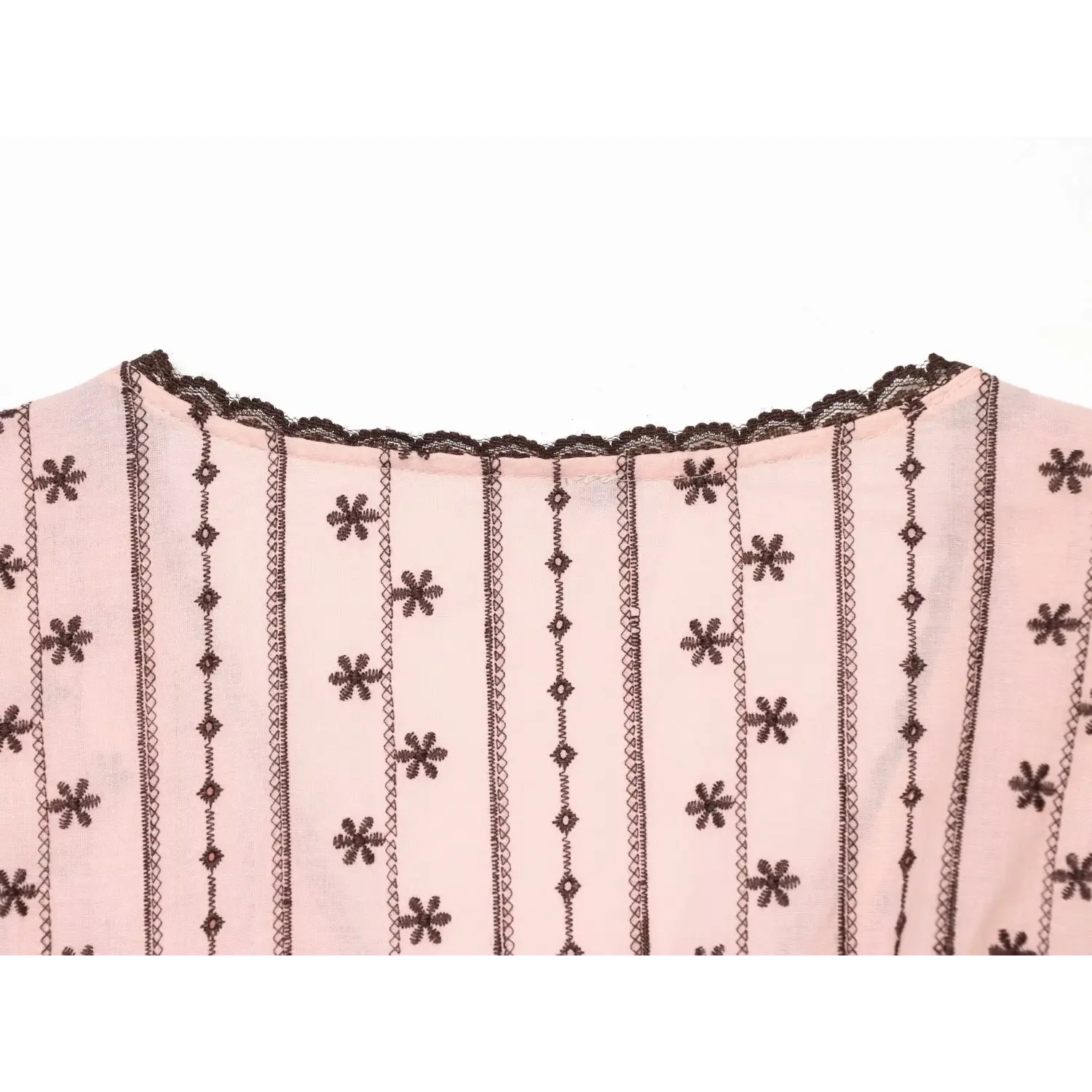 Upper back shot showing continuous scalloped brown lace along rear neckline