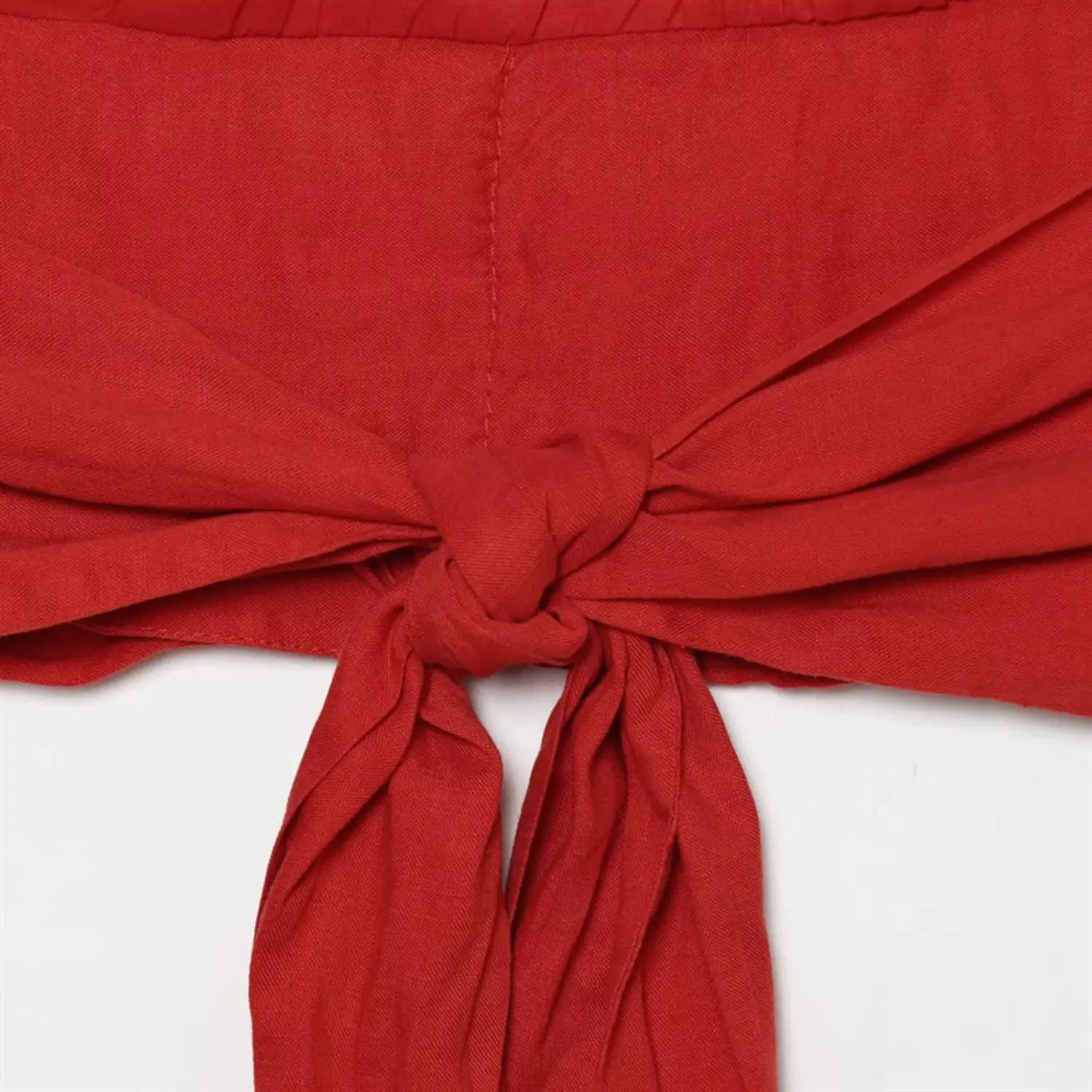Back tie knot macro shot, wide woven fabric strap, neat folded edges, natural crease texture
