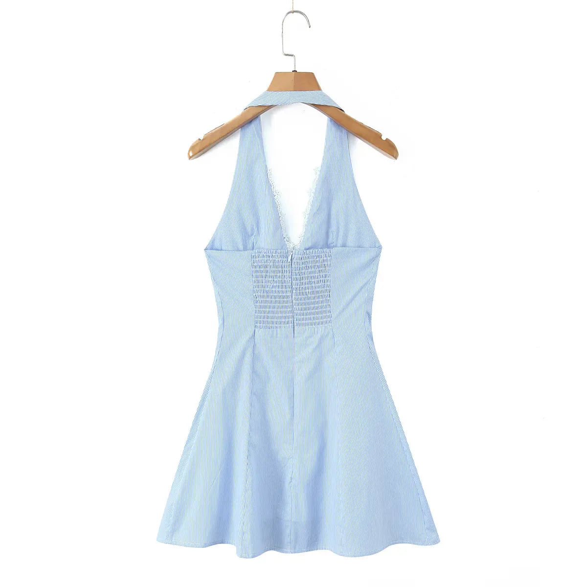 Back view of a blue and white striped halter dress on a wooden hanger, showcasing the smocked panel and hidden zipper.