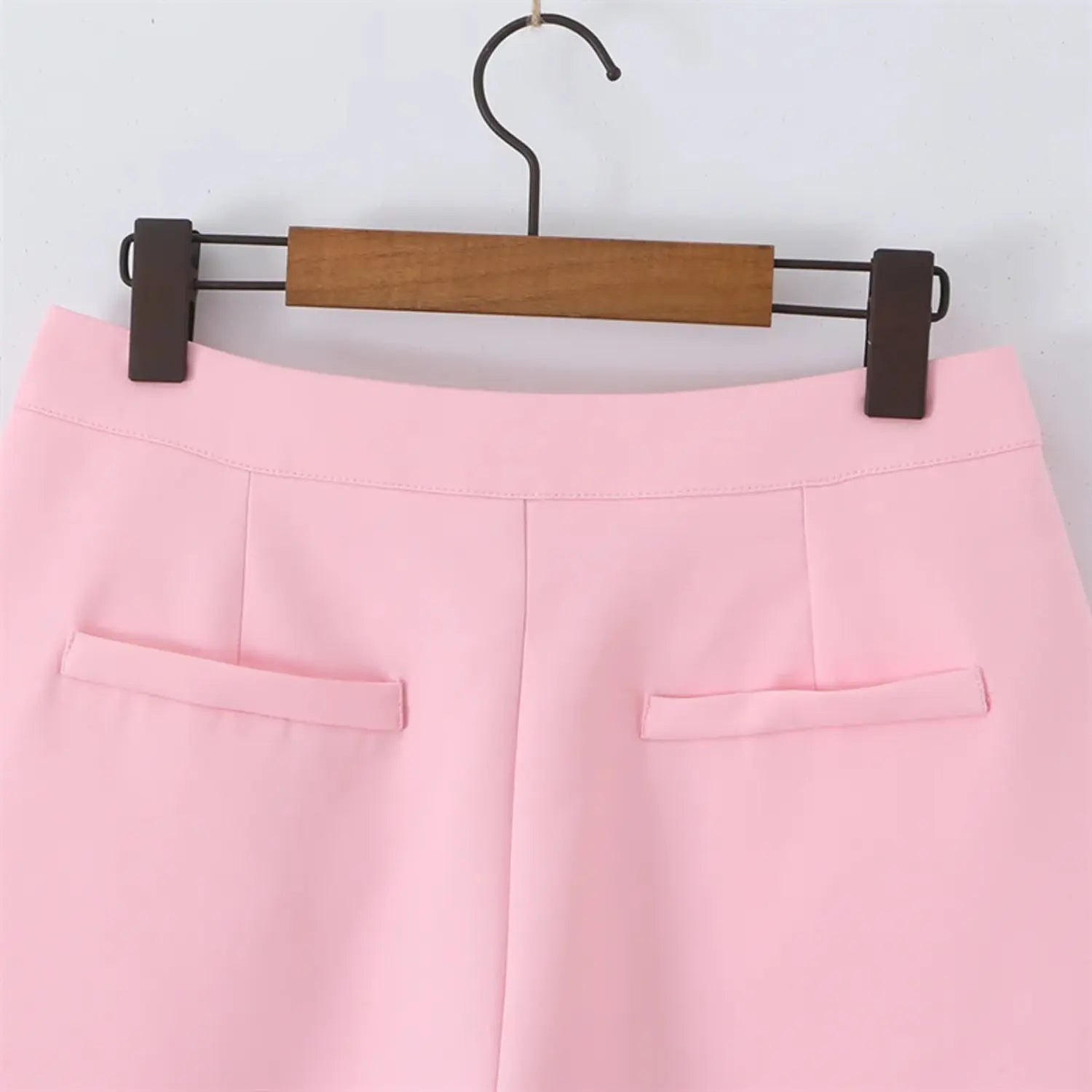 Rear waist partial close-up, two small mock pocket flaps, horizontal back yoke seam, clean tailored stitching