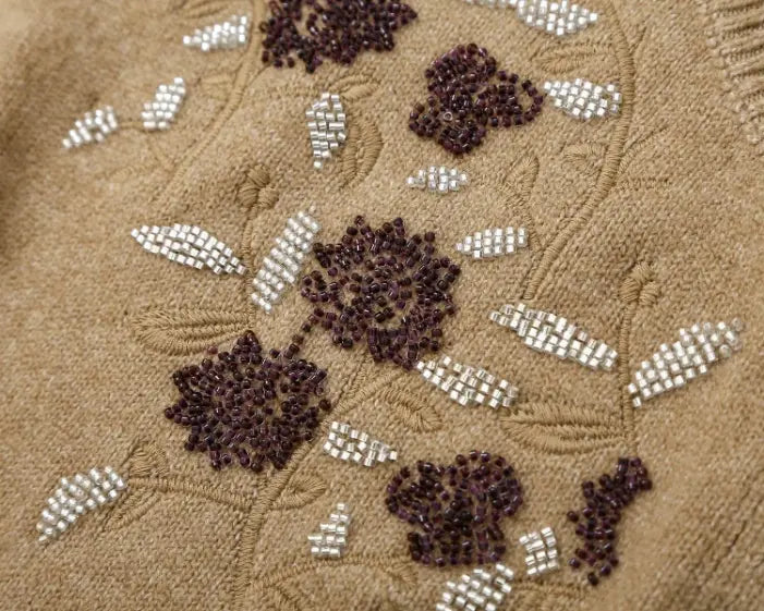 Macro close-up of purple and silver beaded floral embroidery