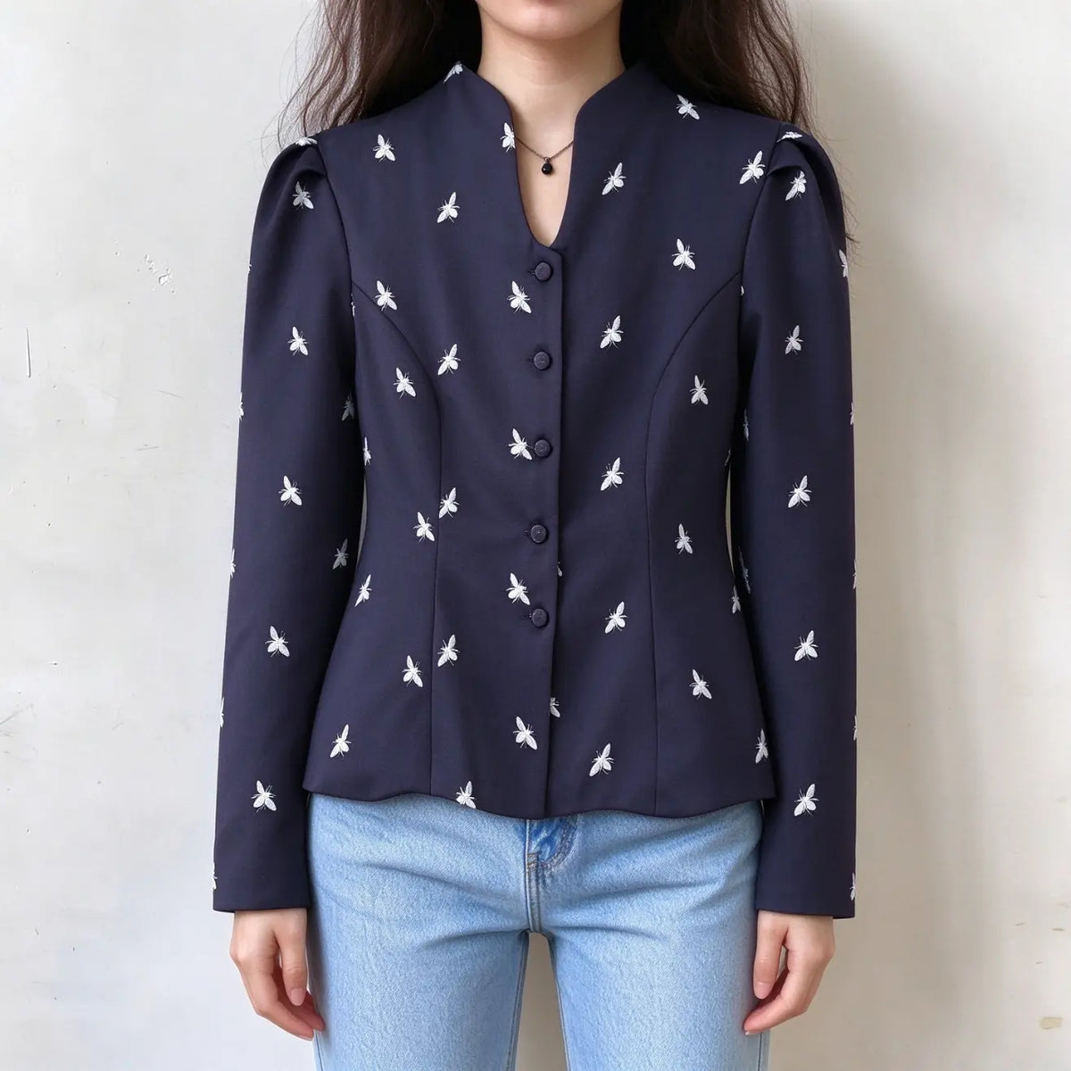 Model wearing navy bee print stand collar button front fitted jacket with jeans, front view