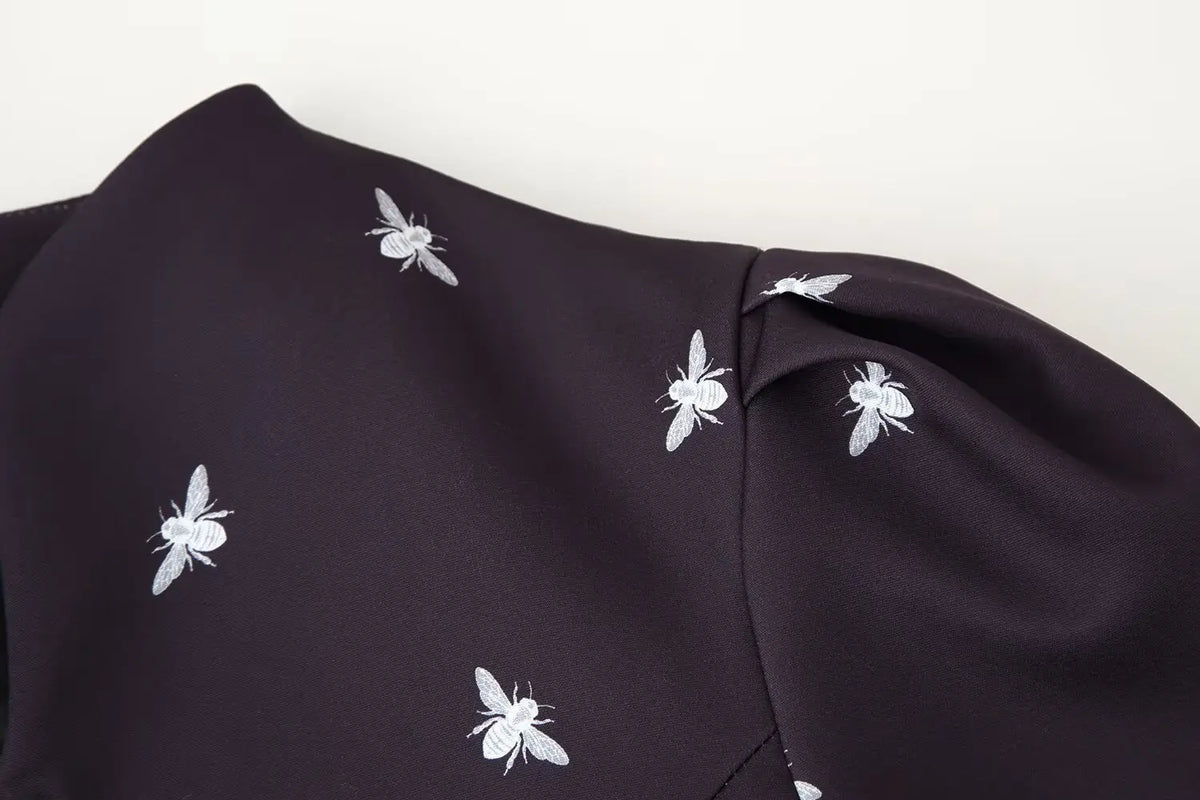 Close-up of puffed shoulder seam and bee print