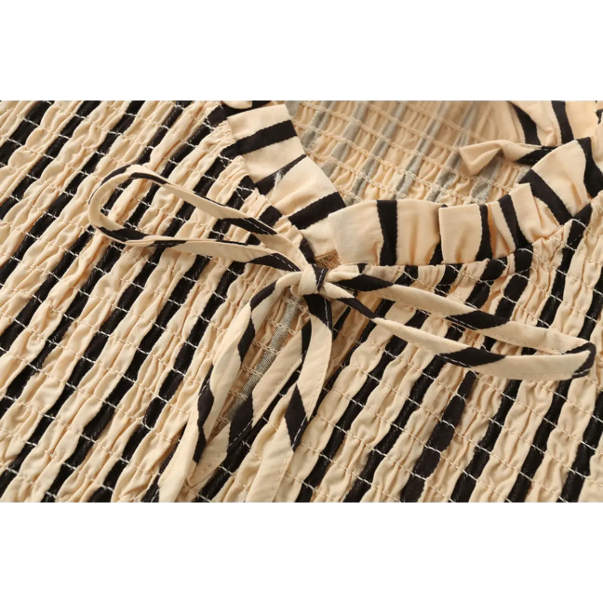 Close-up of the top's striped fabric tie bow at the neckline.