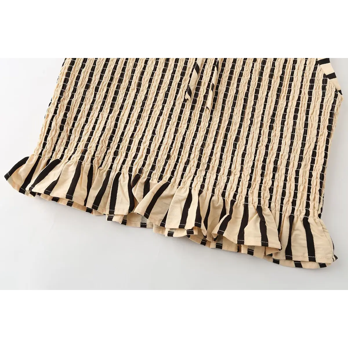 Close-up of the top's full peplum hem and striped pattern.