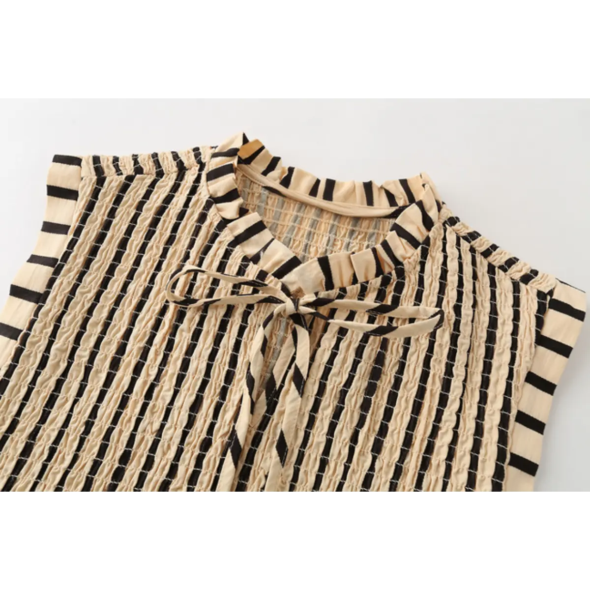 Close-up of the top's ruffled tie-neck and keyhole detail.