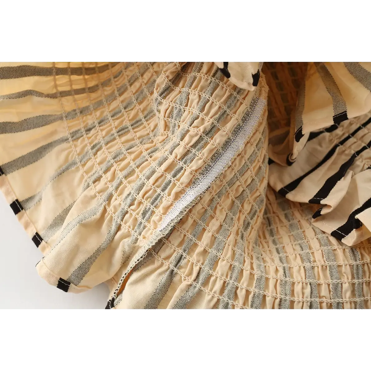 Close-up of the top's ruffled peplum hem and smocked construction.