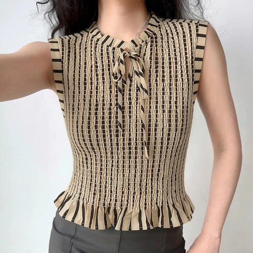 The top styled on a model, highlighting its fitted silhouette, tie neck, and ruffled hem.
