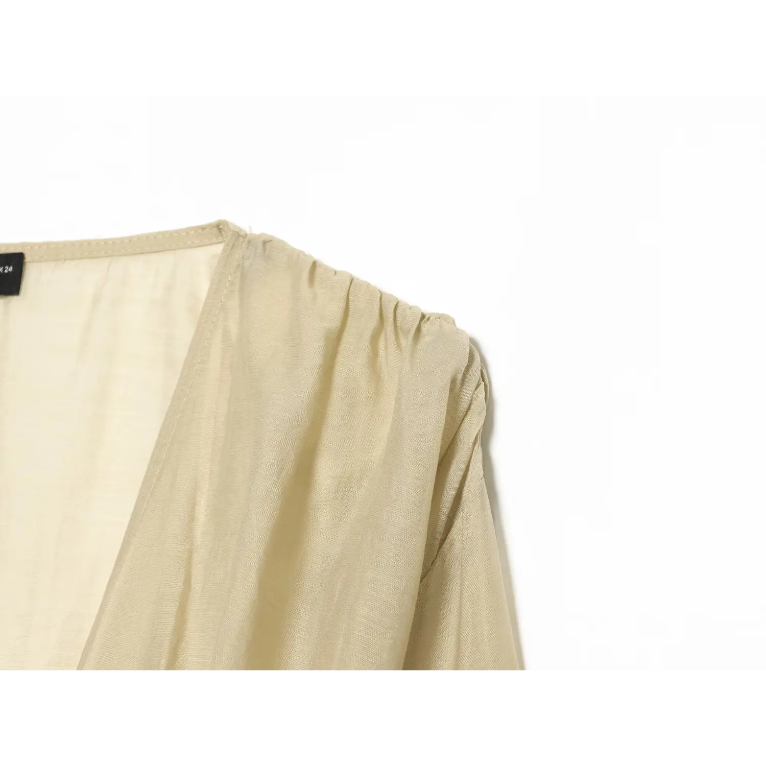 Close‑up shoulder gathered fabric detail of beige balloon sleeve corset blouse