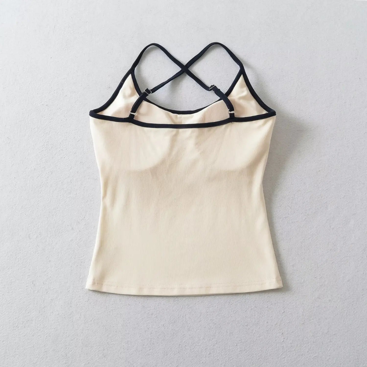 Back view beige camisole featuring black edged adjustable crisscross shoulder straps