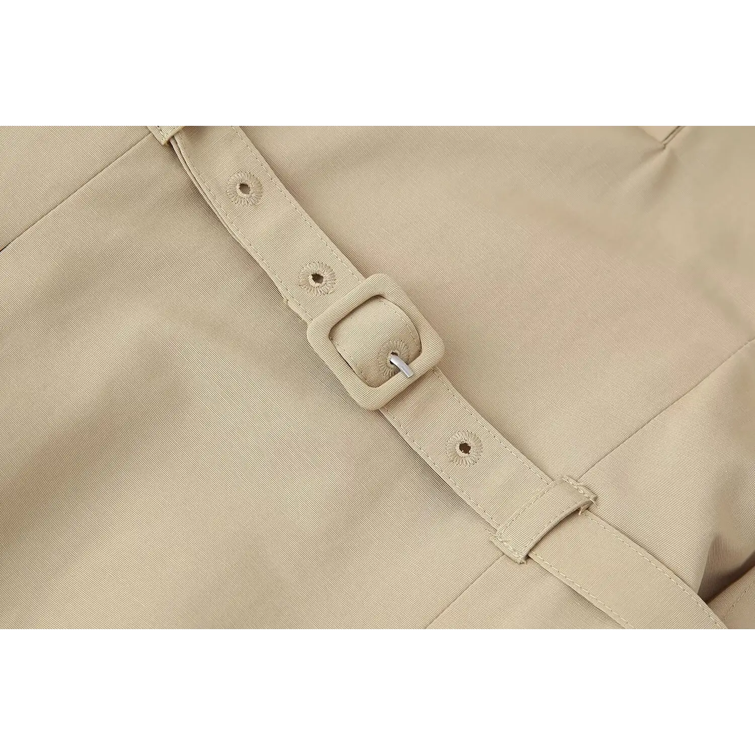 Macro close‑up square fabric covered belt buckle and adjustment eyelet holes